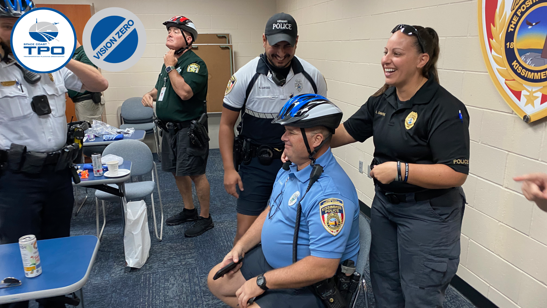 Photo of an officer fit the other with a bicycle helmet.